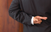 man in a suit with his fingers crossed behind his back
