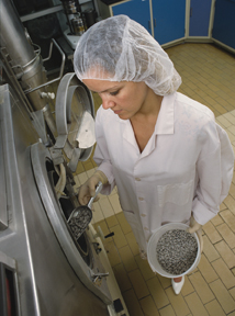 woman wearing a hair net working on a production line