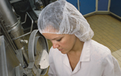 woman wearing a hair net working on a production line