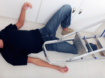 a person laying on the floor after taking a fall off of a step stool