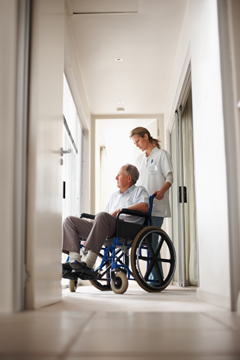 medical aid pushing a man in a  wheel chair